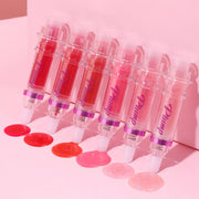 Various shades of Lip Rich Lip Color in applicators with glossy lip swatches on pink background.